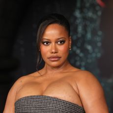 a black woman with dark hair wearing a strapless, checkered gown at a red carpet event