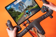 Zwift Play Controllers fitted on bike and showing Zwift game play