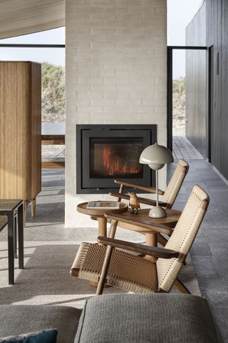 A neutral colored midcentury room with a contemporary small living room fireplace in a dividing wall