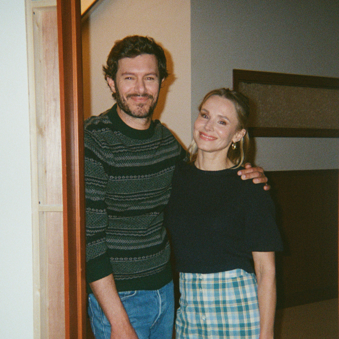 nobody wants this stars adam brody and kristen bell pose together smiling while standing in a doorway on set of the netflix show