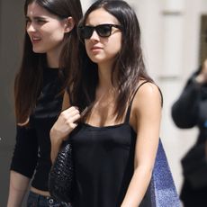Olivia Rodrigo wearing a black spaghetti strap drop-waist summer dress with black motorcycle boots.
