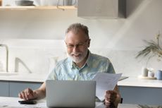 Older man happy looking over his financials 