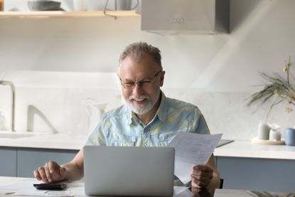 Older man happy looking over his financials 