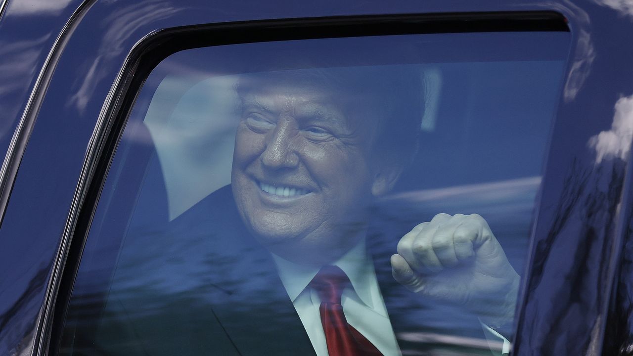 Donald Trump waves to supporters lined along on the route to his Mar-a-Lago estate.