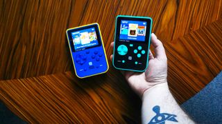 Capcom and Taito Super Pocket handhelds on woodgrain table