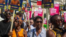 Protesters march from Scotland Yard to Parliament on the first anniversary of the fatal shooting of Chris Kaba