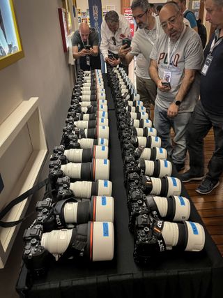 Row of Sony Sony A9 III cameras on a table, surrounded by photographers