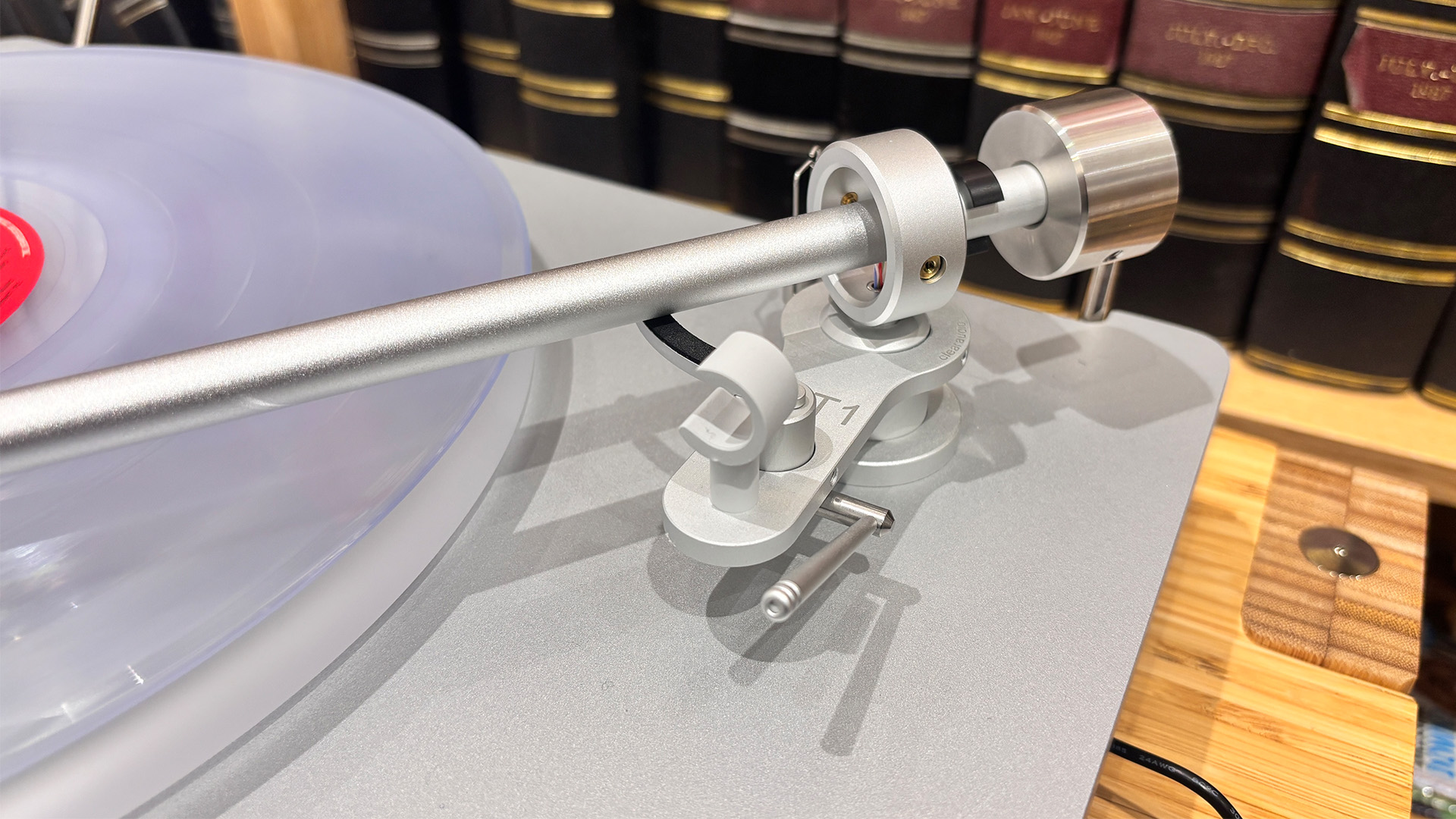 Clearaudio Compass turntable close up on tonearm playing clear vinyl record