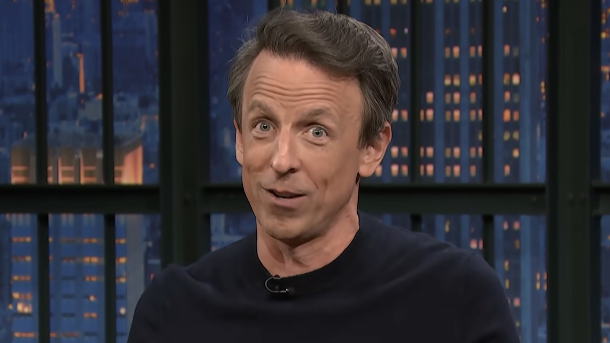 Seth Meyers looking into camera smiling with raised eyebrows on Late Night with Seth Meyers
