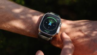 Close up of an Apple Watch on wrist showing AllTrails navigation compass