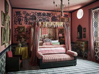 spare bedroom with four poster bed and red walls