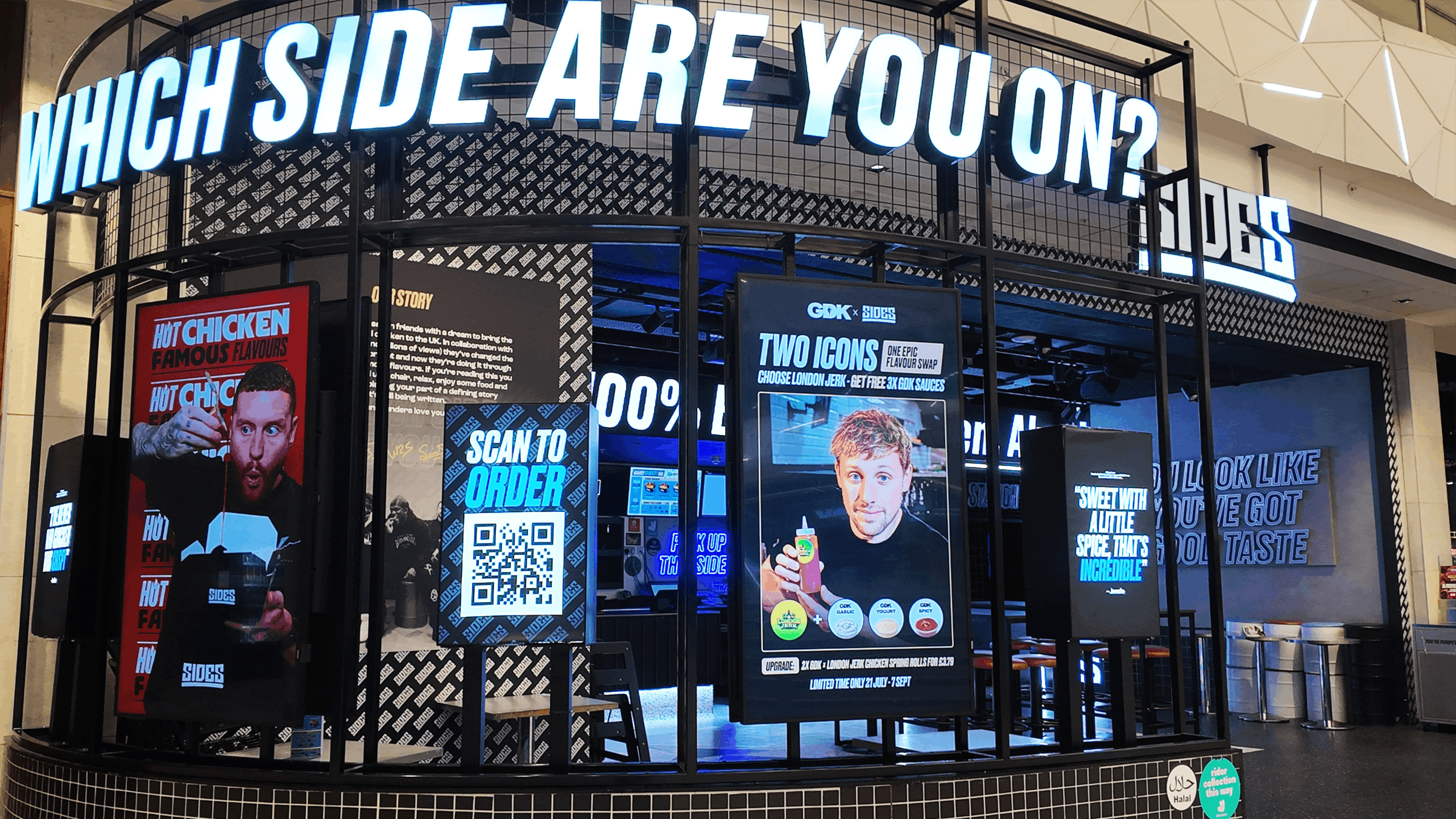 Digital displays showcasing people eating in a food court.