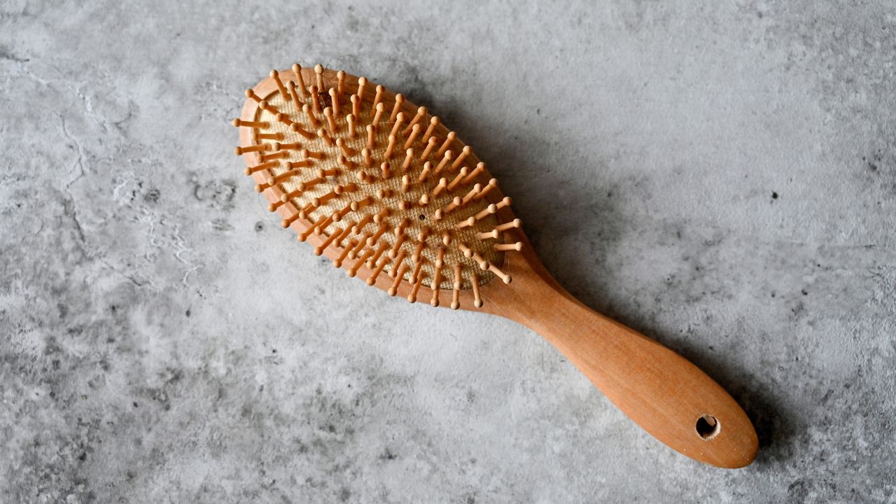 Wooden hair brush on gray background