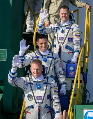 Soyuz MS-22 crew members Sergey Prokopyev, Frank Rubio and Dmitry Petelin wave from the base of their Soyuz-2.1a rocket prior to boarding their spacecraft for launch.