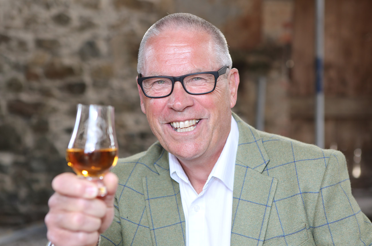 A man with a glass of whisky