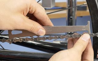 A close up of a Park Tool chain checker in use