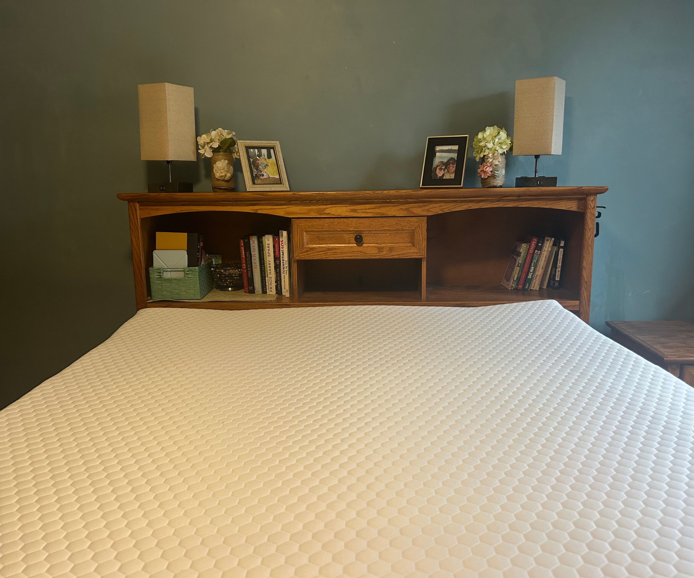 The Helix ErgoAlign Mattress Topper on a bed against teal walls.