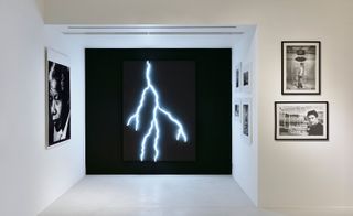 artistic wall with black background and white lightning, with pictures on white walls in an art gallery
