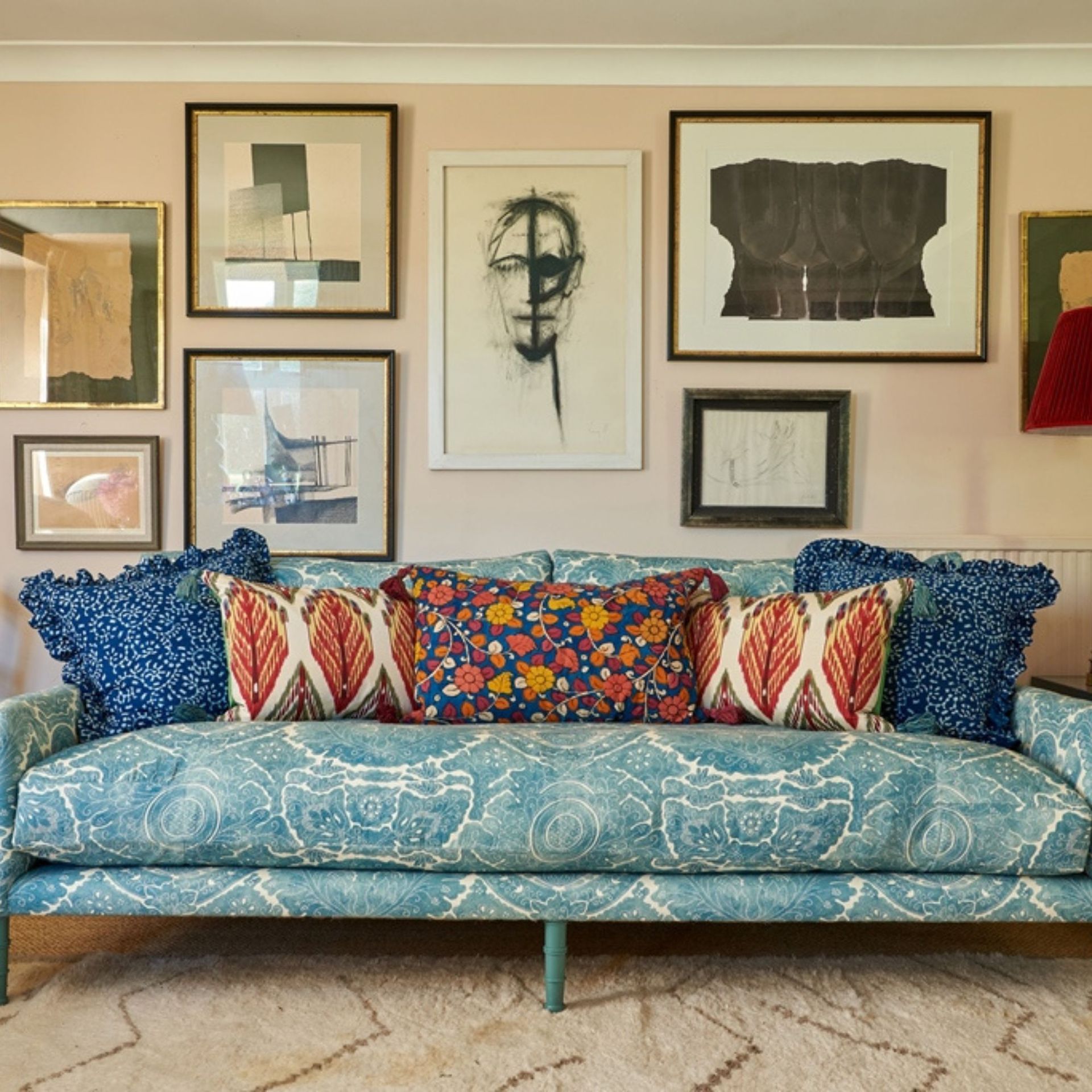 living room with cream walls and sofas with gallery wall behind