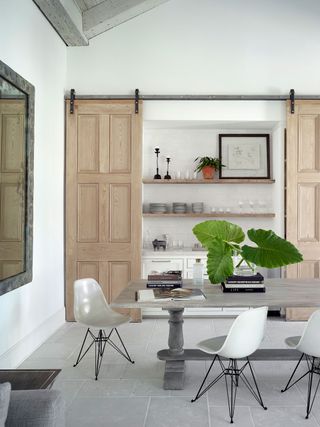 a dining space with storage behind barn doors