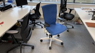 A ErgoChair Plus chair amongst some other black office chairs.
