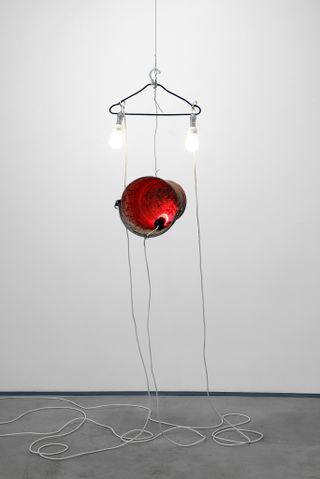 coat hanger with light bulbs and red sphere