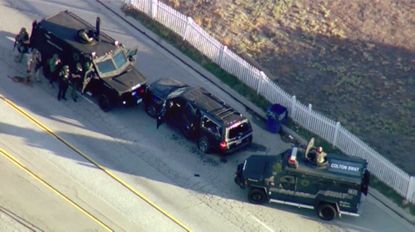 Police surround an SUV following a shootout.