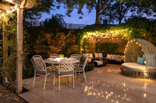 large courtyard garden with dining and seating areas and lighting