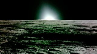 photo from the surface of the moon showing the sun setting with a black sky in the background