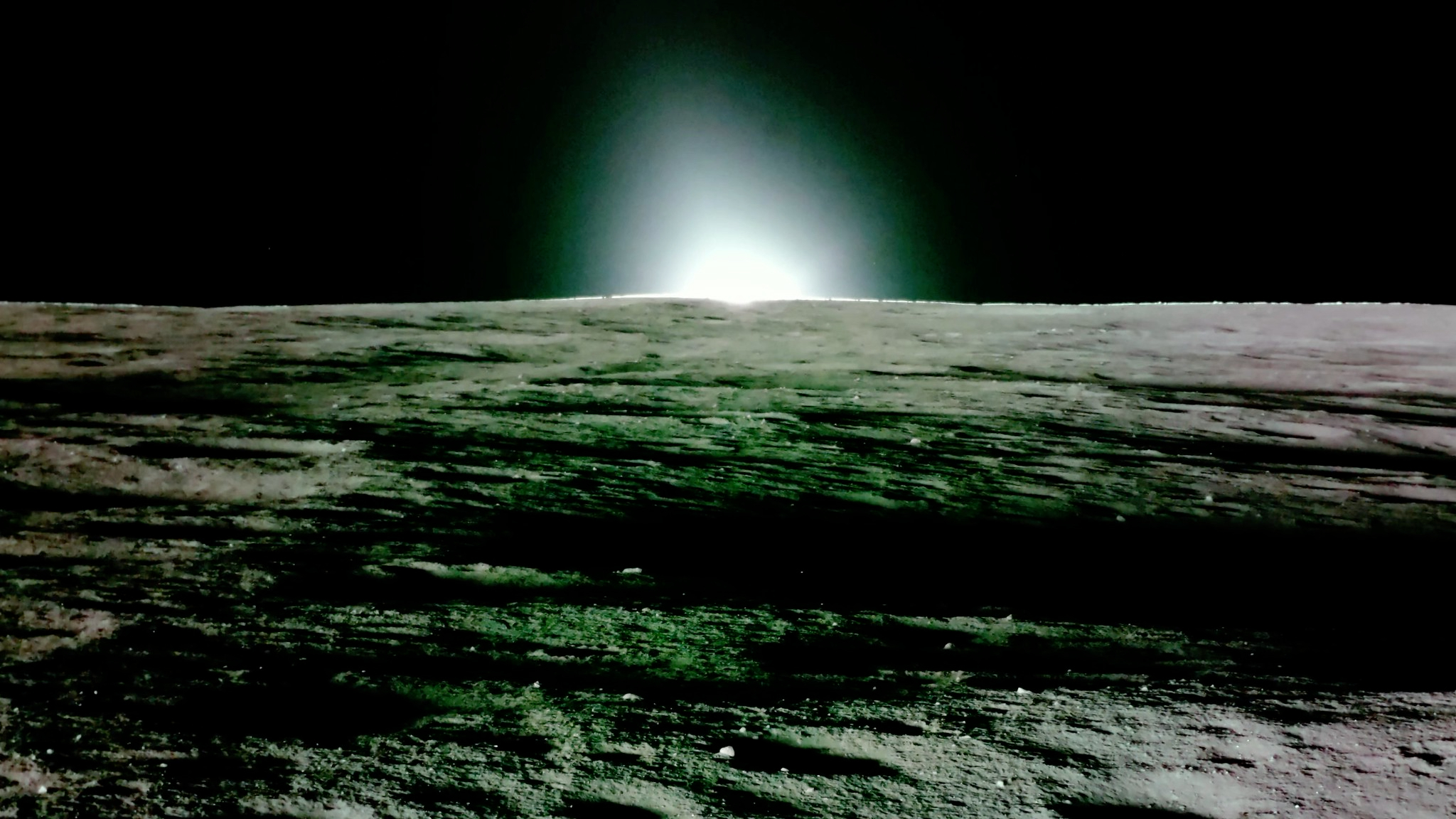 photo from the surface of the moon showing the sun setting with a black sky in the background