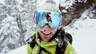 在雪天，戴着护目镜的滑雪者面带微笑