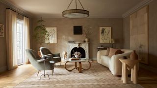 A cream rug on the floor with an elegant sofa and accent chairs