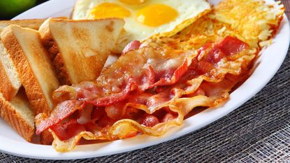 Crispy baocn next to bread and fried eggs on a plate