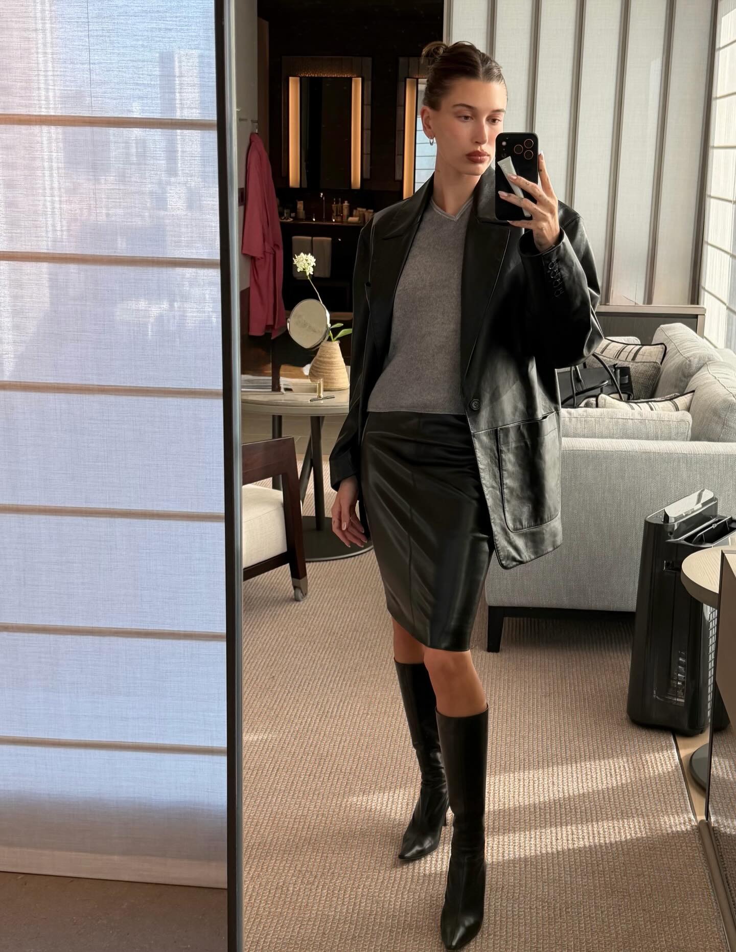 Hailey wears a leather blazer, gray sweater, leather pencil skirt and black knee high boots.