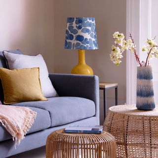 Living room with pink walls and purple sofa and yellow lamp with blue patterned lamp shade