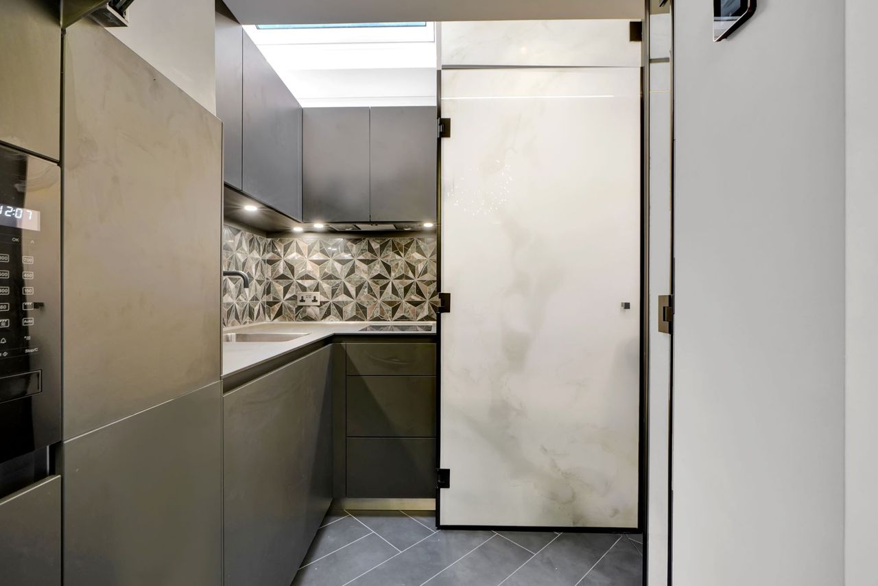 A grey kitchen with inbuilt fridge