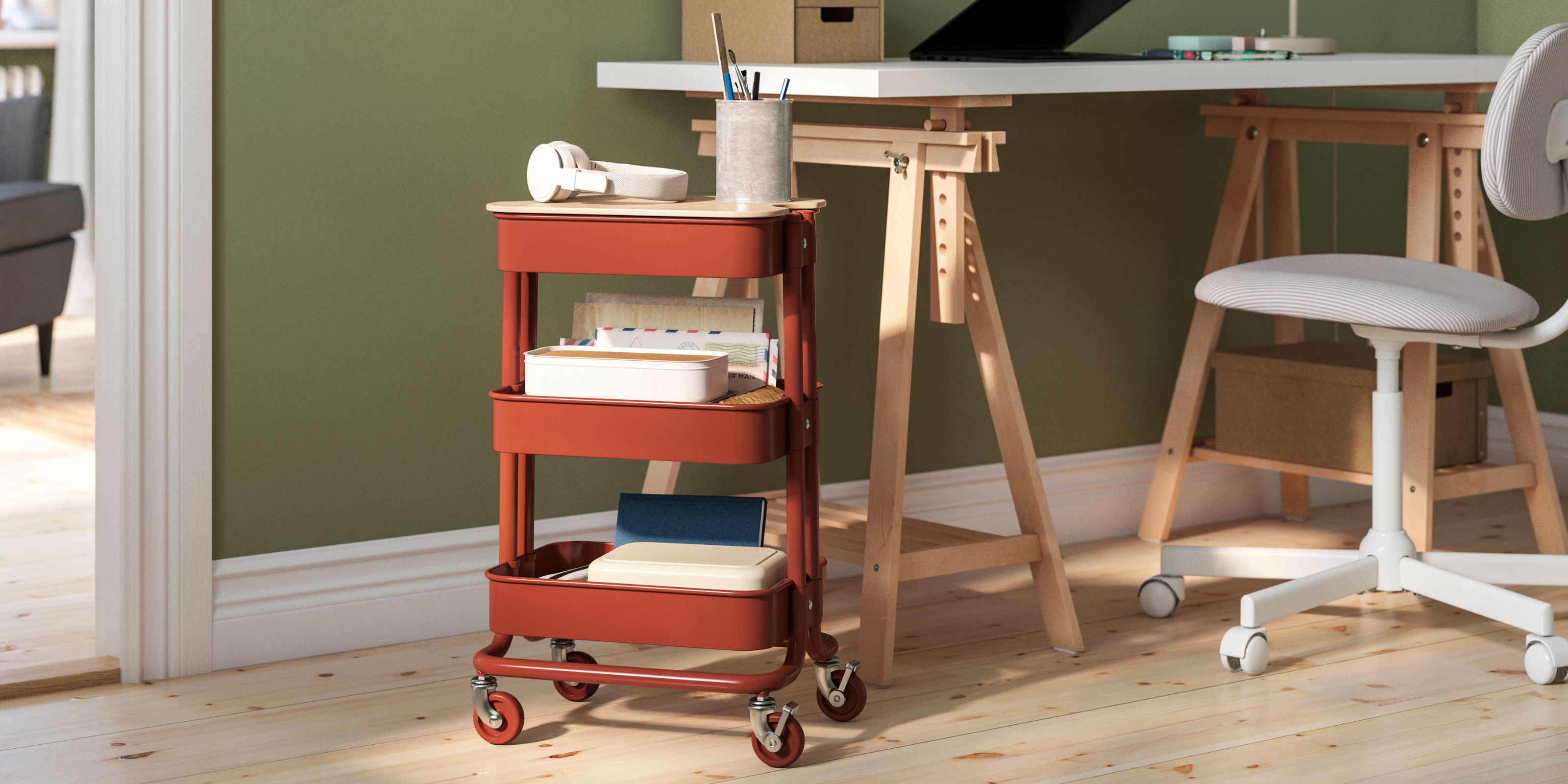 IKEA's Raskog trolley in terracotta in a green office room