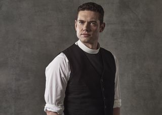 Tom Brittany as Rev Will Davenport, wearing his dog collar over a white shirt with the sleeves rolled up