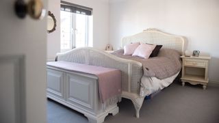 A bedroom with a trunk at the foot of the bed