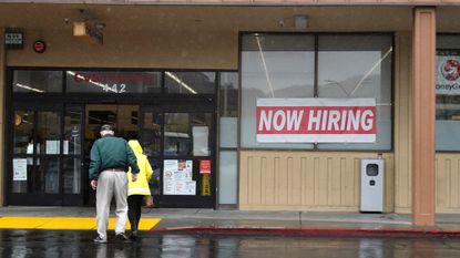 People walk past a 'Now hiring' sign outside of a CVS in San Rafael, California.