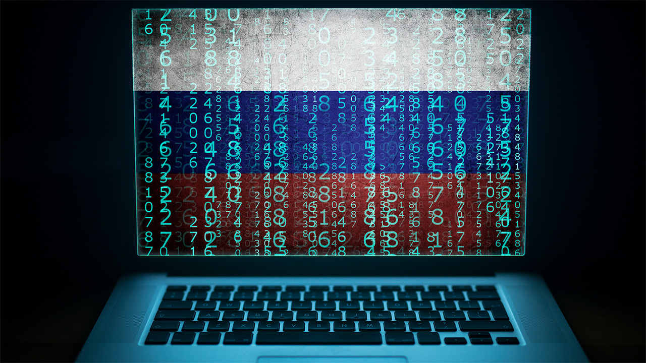 Computer with binary computer code and Russian flag on the screen