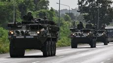 Royal Thai Army soldiers are pictured on armoured vehicles on a road in Chachoengsao province