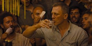 Daniel Craig as James Bond playing a drinking game in Skyfall