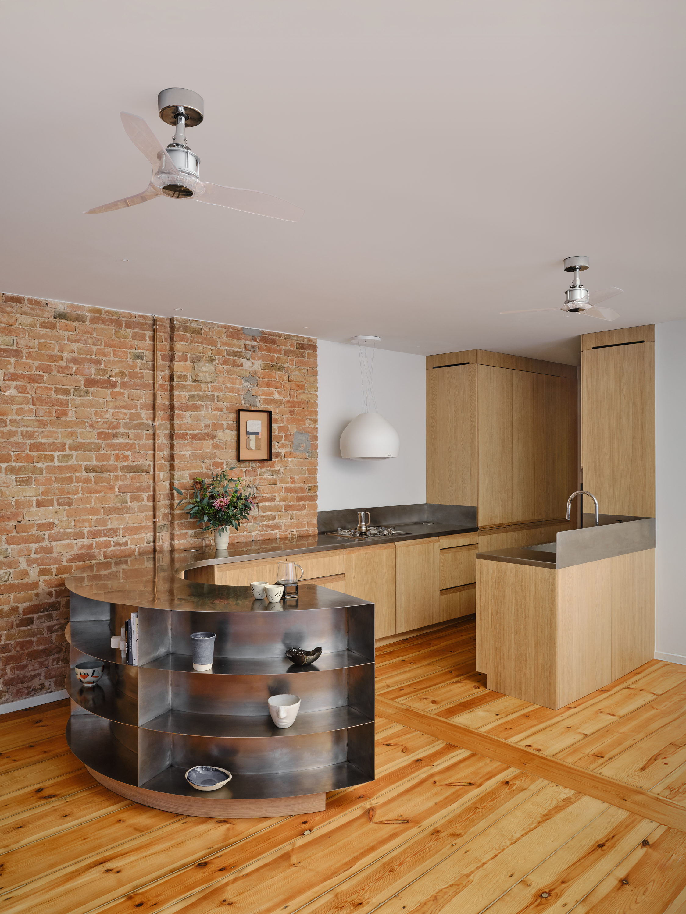 A kitchen in all wood, with a metal extension used as storage