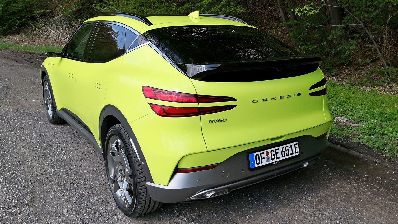 Angled side view of green GV60 parked at side of road