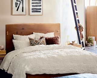 Anthropologie Textured Piazza Quilt in white in boho style bedroom with wooden headboard and ladder