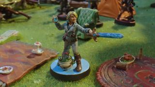 A miniature of Adaine with her sword and frog familiar
