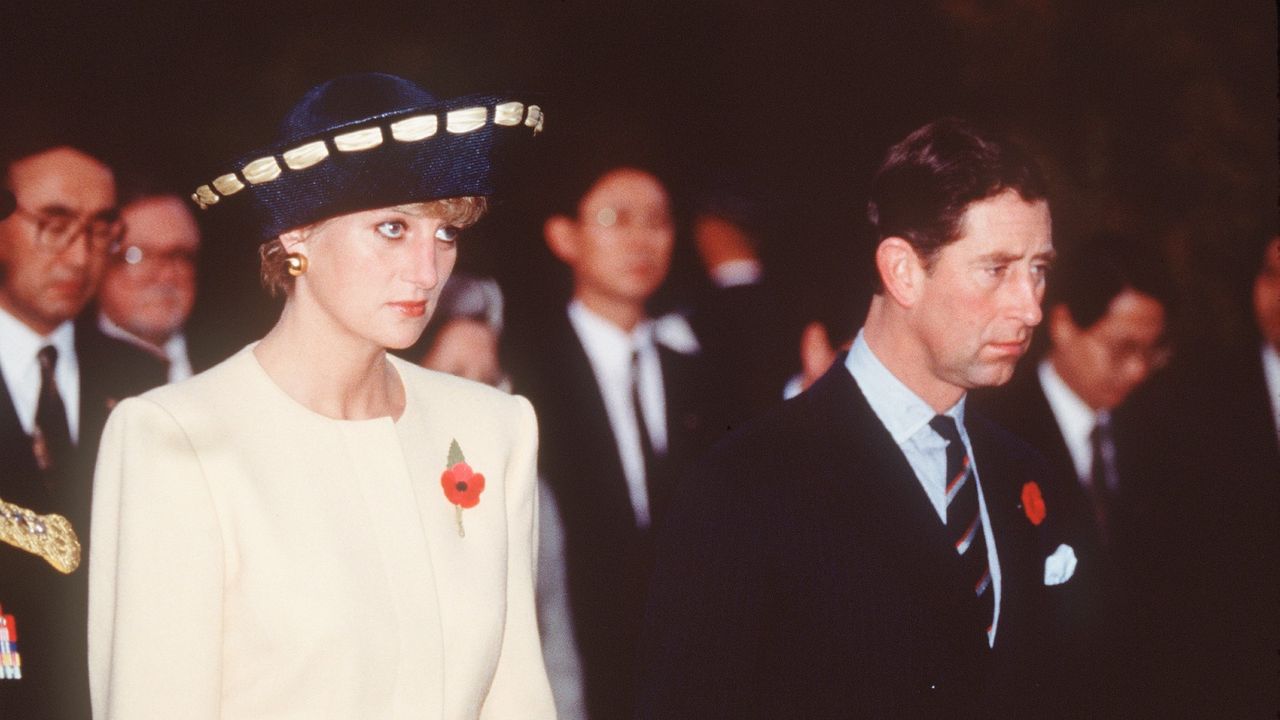 Prince Charles, Prince of Wales and Diana, Princess of Wales, wearing a yellow and navy blue dress and jacket designed by Catherine Walker and a hat by Philip Somerville, visit the National Cemetery