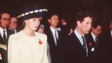 Prince Charles, Prince of Wales and Diana, Princess of Wales, wearing a yellow and navy blue dress and jacket designed by Catherine Walker and a hat by Philip Somerville, visit the National Cemetery