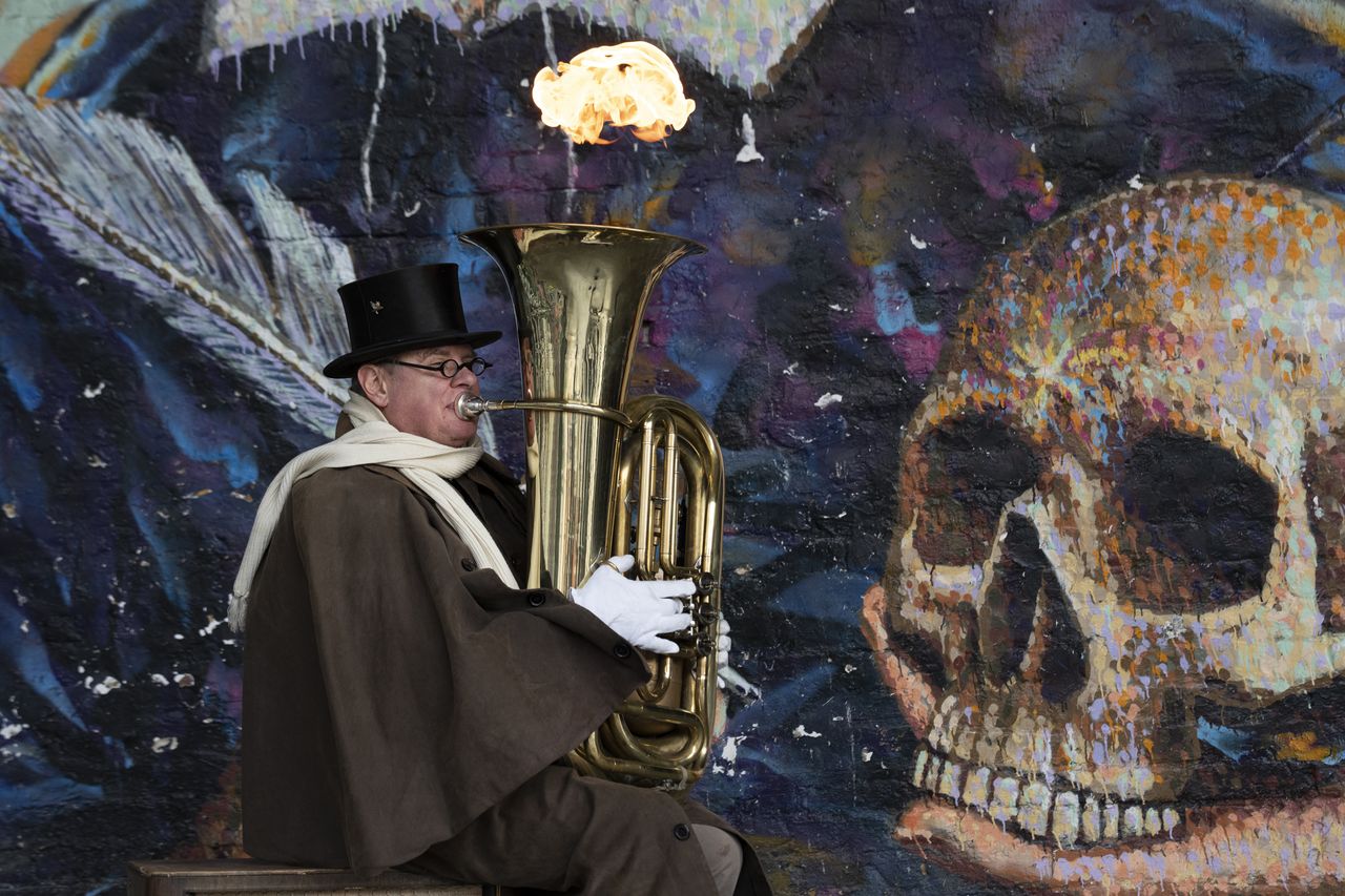 An entertainer breathing fire from an instrument